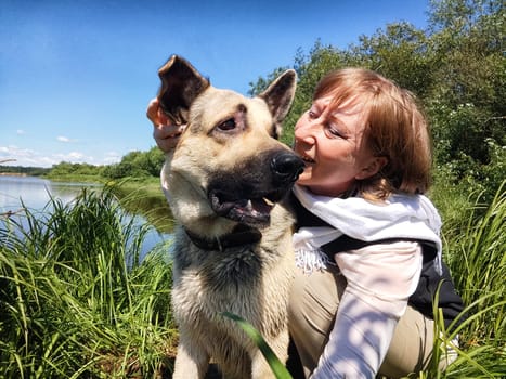 Dog German Shepherd and woman or girl in nature in summer, spring, summer day. Russian eastern European dog and the mistress, trainer veo outside and outdoors