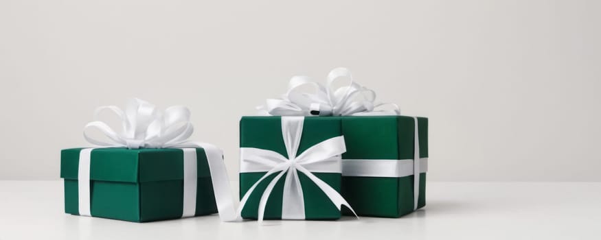 Three dark green gift boxes with white ribbons, conveying a sense of celebration and anticipation for the joy of gifting