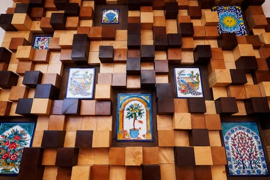 Wooden panel of light and dark cubes with inserts of colorful paintings. High quality photo