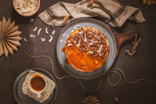 Delicious caramel cake with small pieces of pecan nuts and coconut shavings.