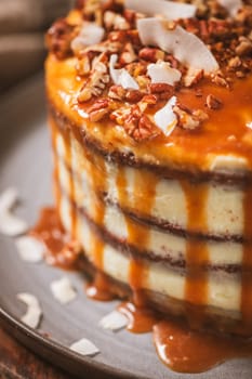 Delicious caramel cake with small pieces of pecan nuts and coconut shavings.