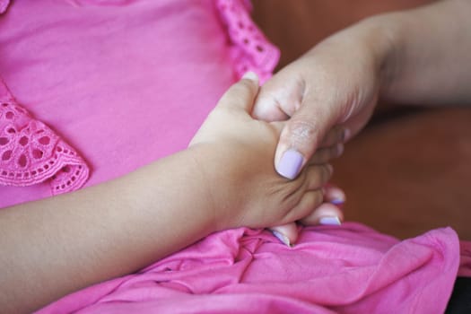 mother holding hand of baby child