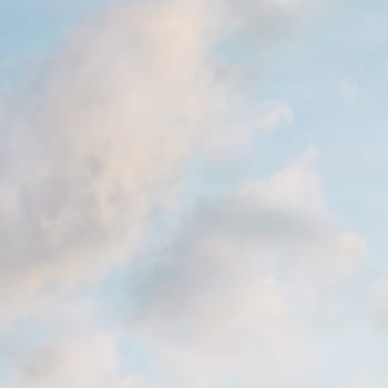 Background of blue sky with pale pink clouds at sunset