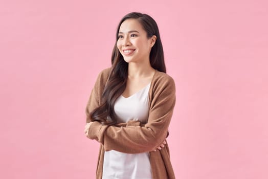 Portrait of a confident smiling Asian woman standing with arms folded isolated