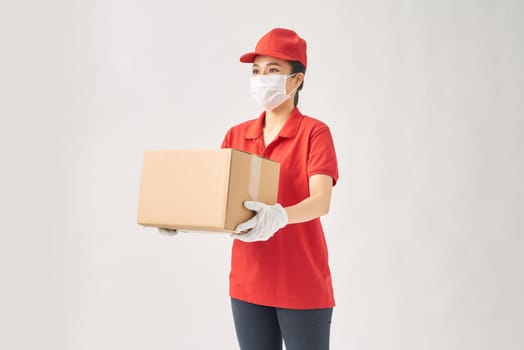 Young woman holding cardboard box or parcel in hands smiling happily