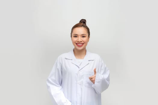 Asian young female doctor thumbs up gesture in white background