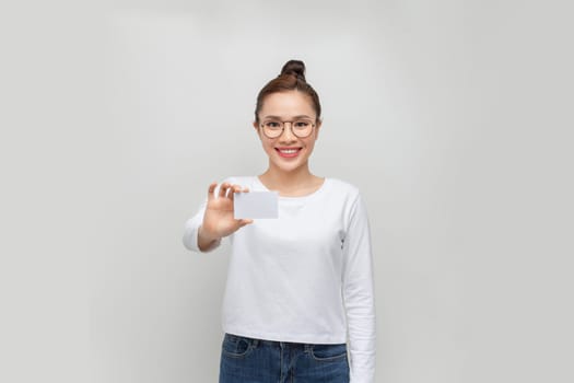Happy asian woman showing blank credit card. 
