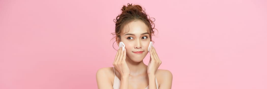 Young attractive lady using face toner and cotton pad