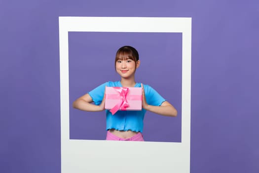 Photo of charming excited lady hold present box looking inside photo frame empty space on color background