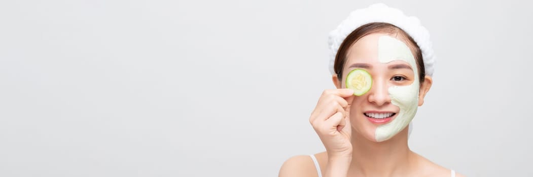 Beautiful young woman with cucumber facial mask on white background. Banner