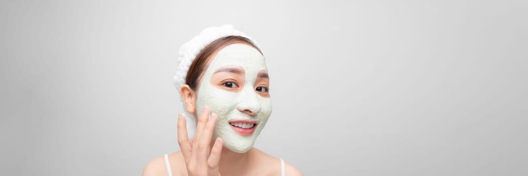 Skin care. Young woman with cosmetic clay mask on white banner