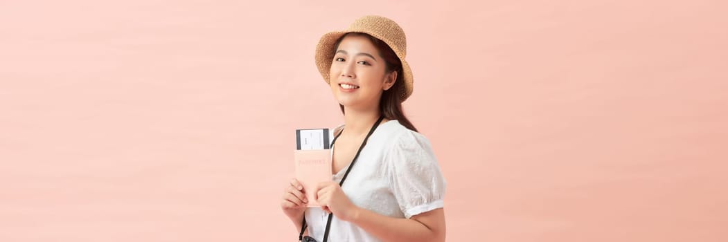 Young Asian woman with passport and ticket on pink background with space for text for banner