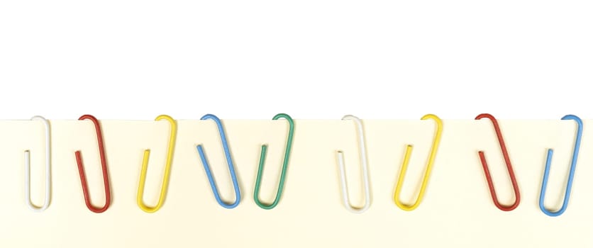 a row of colored paper clips on a blank sheet of paper