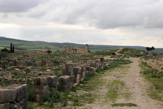 Volubilis Roman ruins in Morocco- Best-preserved Roman ruins located between the Imperial Cities of Fez and Meknes on a fertile plain surrounded by wheat fields.