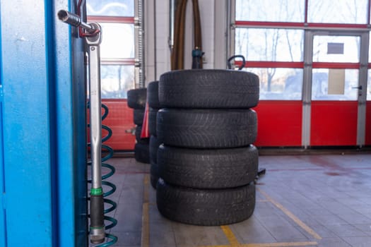 A set of tires for seasonal replacement near the lift in the tire workshop. The concept of seasonal car tire replacement.