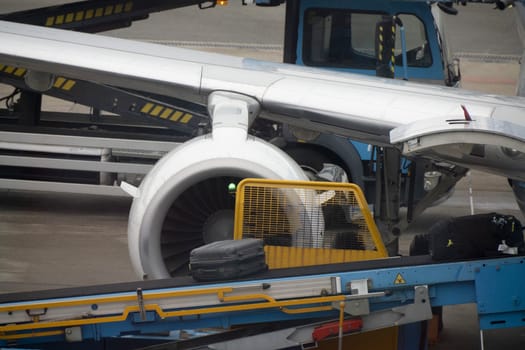 Detail of baggage uploading to airplane while parking at the terminal