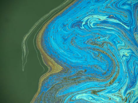 oil spreading on sea surface Aerial top down view like a abstract painting with the rainbow-colored oil spill pattern detail