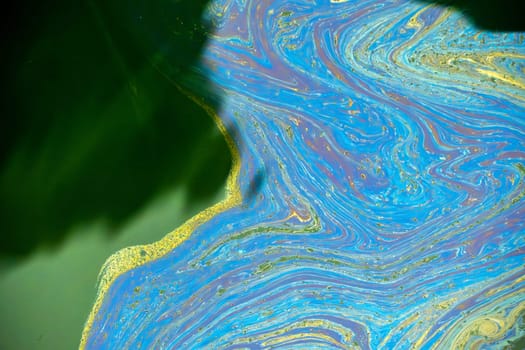 oil spreading on sea surface Aerial top down view like a abstract painting with the rainbow-colored oil spill pattern detail