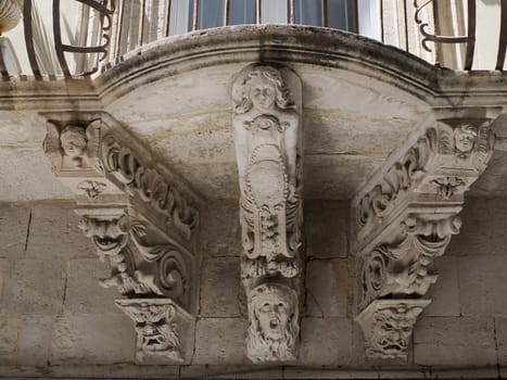 balcony sculpture ortigia syracuse old buildings street view on sunny day Sicily, Italy