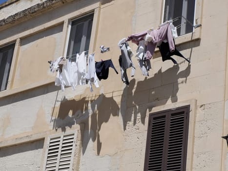 clothes on balcony of ortigia syracuse old buildings street view on sunny day Sicily, Italy