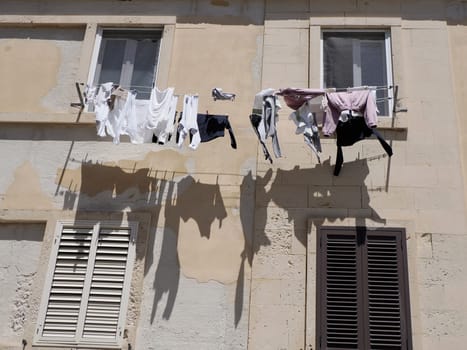 clothes on balcony of ortigia syracuse old buildings street view on sunny day Sicily, Italy