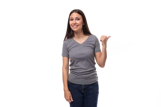 portrait of a young pretty brunette european woman dressed in a gray basic t-shirt with advertising space.