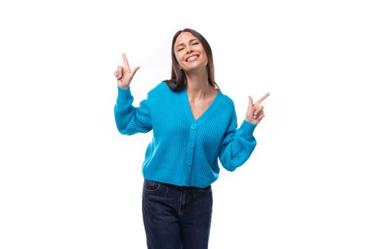 young charming brunette lady dressed in a blue V-neck sweater actively jests on a white background with copy space. advertising concept.