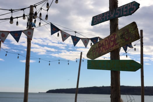 Signs on a beach pointing in different directions. High quality photo