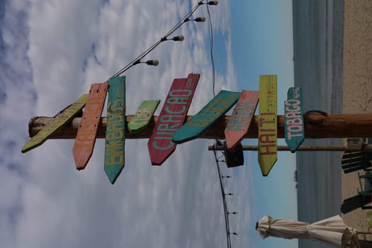 Signs on a beach pointing in different directions. High quality photo