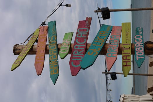 Signs on a beach pointing in different directions. High quality photo