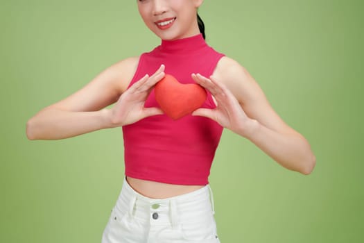 Beautiful woman hold red heart, isolated on green background