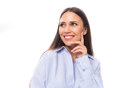 close-up of a young slender beautiful European brunette business woman with light makeup in a light blue shirt.