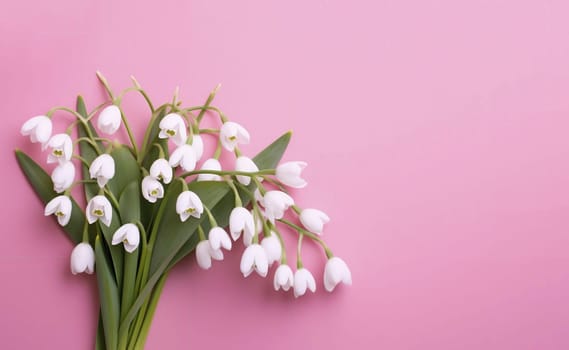 Bouquet of white snowdrops on a pink background. Background for cards and banners. Copy space. Spring holiday background.