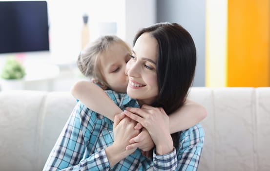 Little girl hugging young woman at home. Happiness of motherhood concept