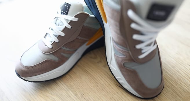 Close-up of grey sneakers on table. Sport footwear for running and fitness. Amazing and trendy pair of shoes. Active lifestyle. Nice texture with white sole and laces