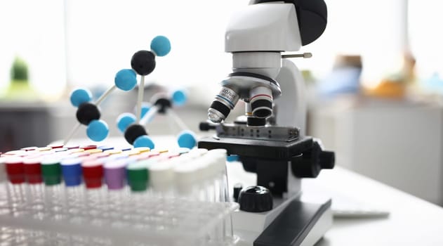 Close-up of modern laboratory and glass flasks on table. Black and white microscope and science stuff. Empty tubes in desk in office. Lab and investigation concept