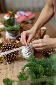 Woman making Christmas arrangement with fir branches. craft handmade decor.