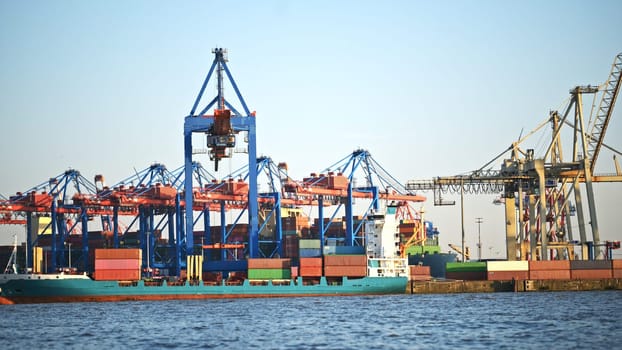 Cargo crane in sea port with containers for import and export shipping in Hamburg. Harbor commercial dock with equipment for global logistic merchandise delivery