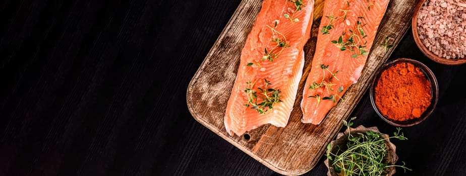 fillet of trout red fish with herbs and salt on a cutting board, top view with copy space