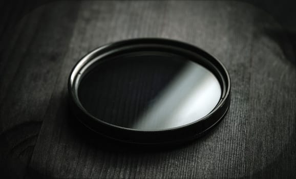 Neutral density filter filter for photo and video shooting on a black wooden table