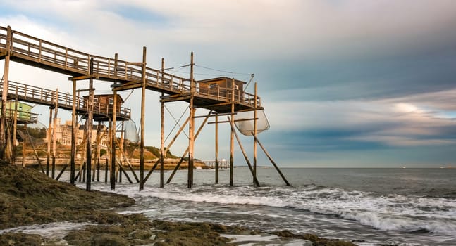 Traditional fisherman hut on stilts with carrelet fishing net. Typical wooden houses for fishing at beach
