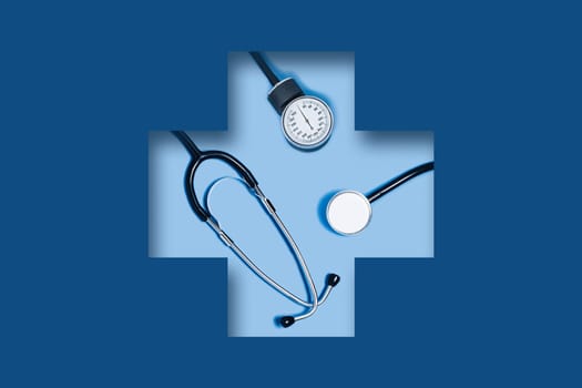 3D paper cut out art. Medical classic blue background with stethoscope lying in a carved medical cross.