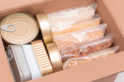 Food Reserves or Donation Box: Carton Box with Canned Food, Cereals and Grocery. Emergency Food Storage in Case of Crisis. Free Social Help, Blessings and Care. Strategic Food Supplies