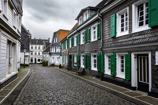 Beautiful Slate houses and paving stones road, sightseeing in Greafrath, North-Rhine Westphalia, Germany