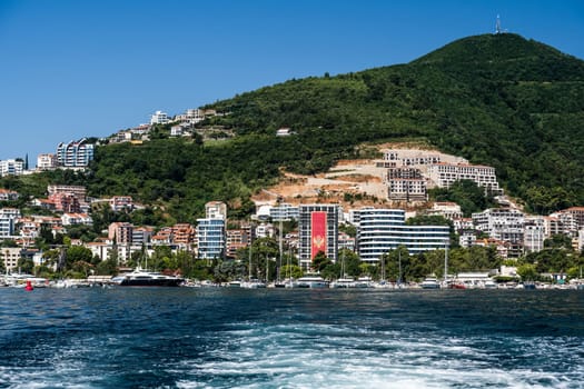 Modern Mediterranean city in Montenegro, view from Adriatic sea. Balcan architecture with mountains on background