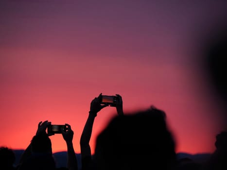 many people photographing red sunset