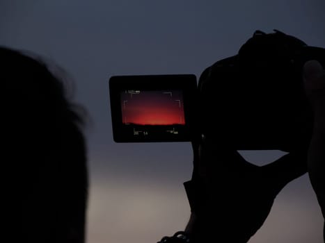 many people photographing red sunset