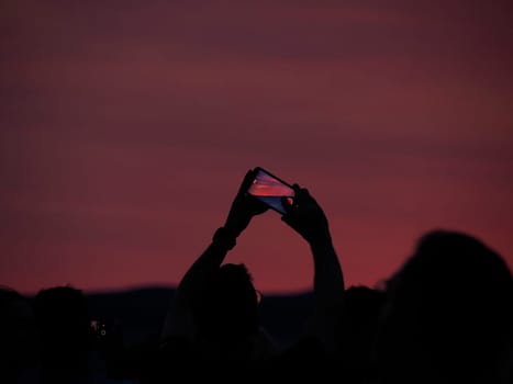 many people photographing red sunset