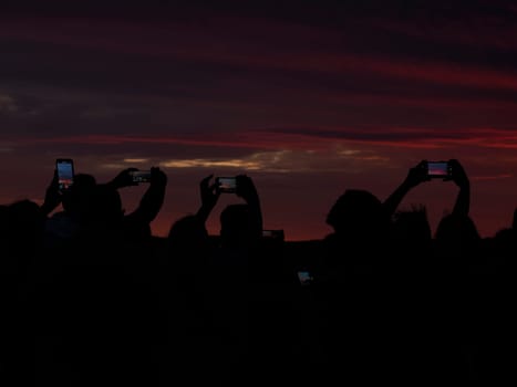 many people photographing red sunset