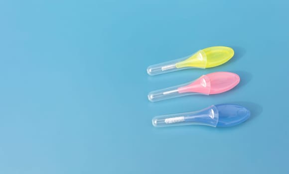 Mockup Colorful Interdental Toothbrush For Cleaning Between Teeth On Blue Background . Toothpick With Soft Bristles, Oral Tooth Cleaning Tool. Horizontal, Copy Space For Text. Dental And Orthodontic.